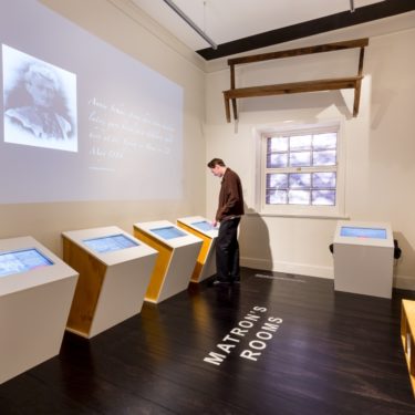 Person viewing In This Place exhibition at Migration Museum