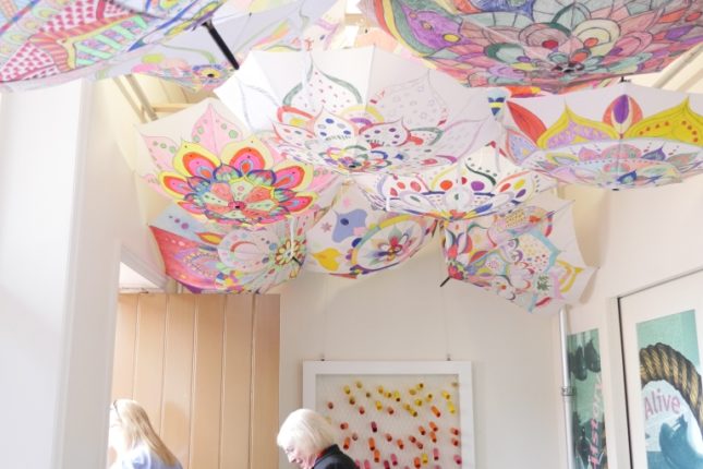 Colourful display of hand-decorated umbrellas hanging from the ceiling